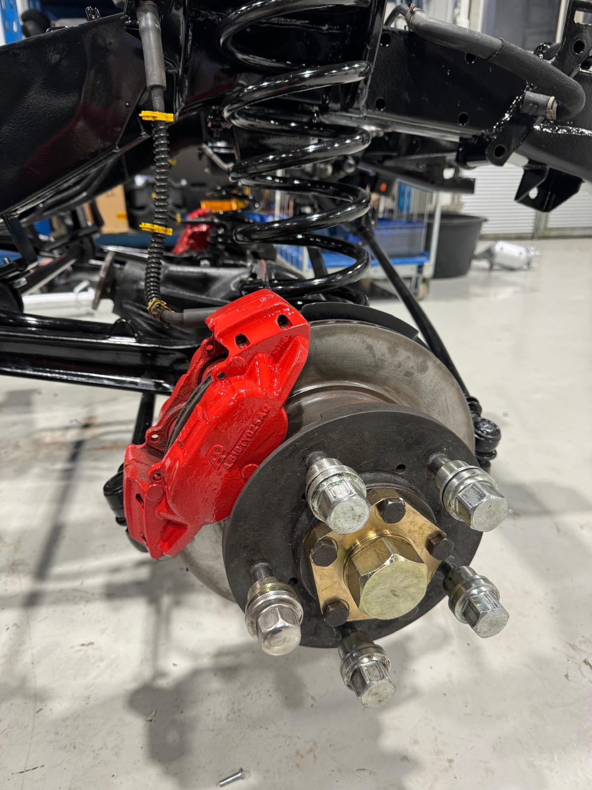 Rear brake hub close-up — red caliper, fresh discs